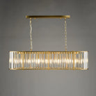 An illuminated rectangular chandelier with a gold frame and clear glass rods against a grey background.