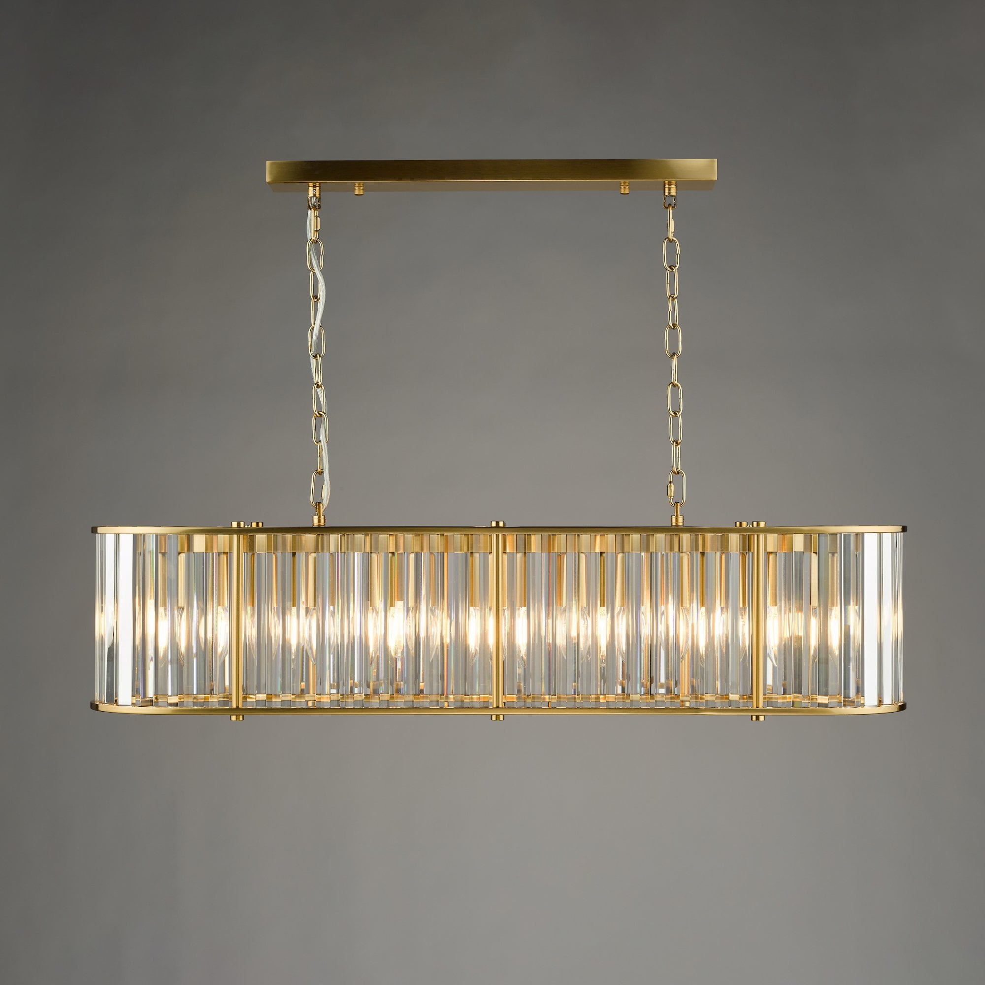 An illuminated rectangular chandelier with a gold frame and clear glass rods against a grey background.