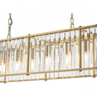 A side view of the illuminated rectangular chandelier, showcasing its gold frame and glass rods.