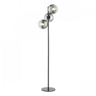 A sleek, modern floor lamp with three spherical smoked glass shades on a black pole.
