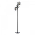 A modern floor lamp featuring a black base and pole, with three smoky glass globes.