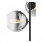 Detailed view of one illuminated smoked glass sphere on the modern floor lamp.