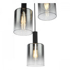 Close-up of three modern pendant lights with smoked glass shades and exposed Edison bulbs.