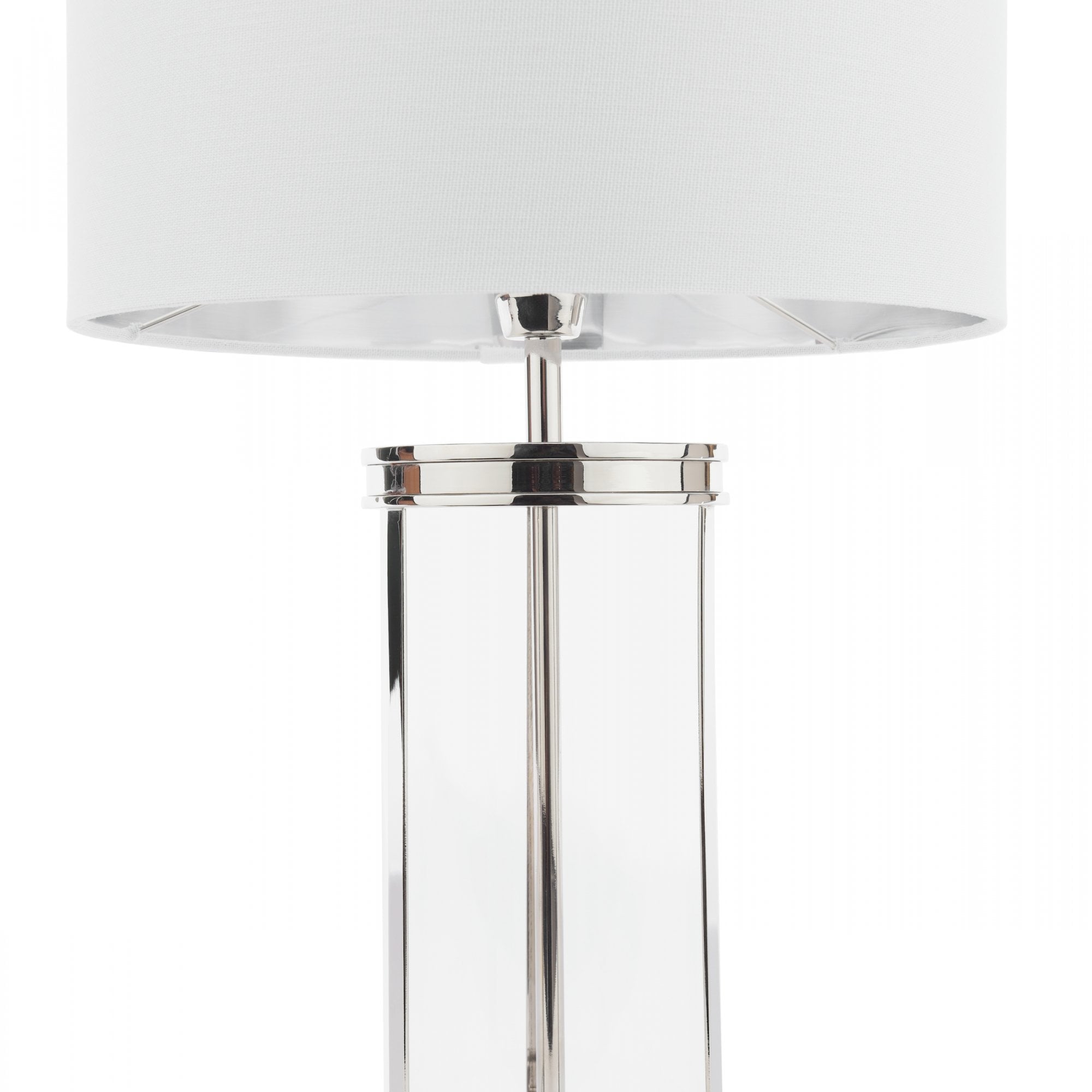 Close-up of a glass and metal table lamp with a white lampshade.