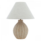 A studio shot of a wicker table lamp with a conical off-white shade.
