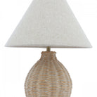 A close-up studio shot of a wicker table lamp with a conical off-white shade.