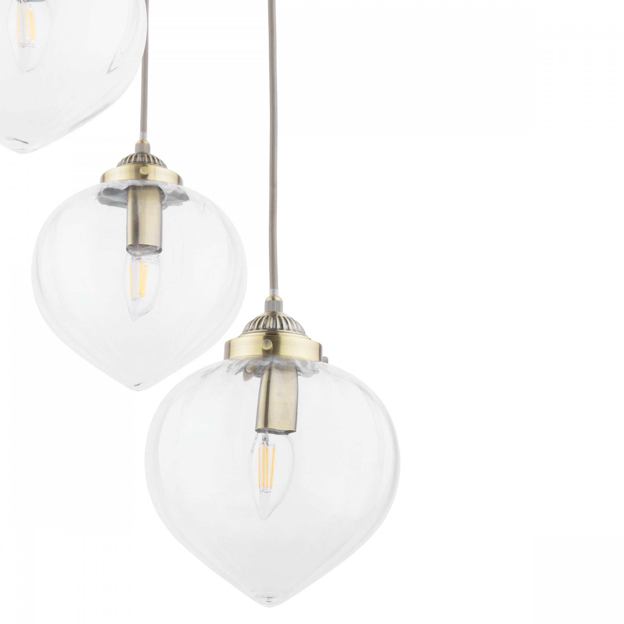 Close-up of two clear glass pendant lights with brass fittings.