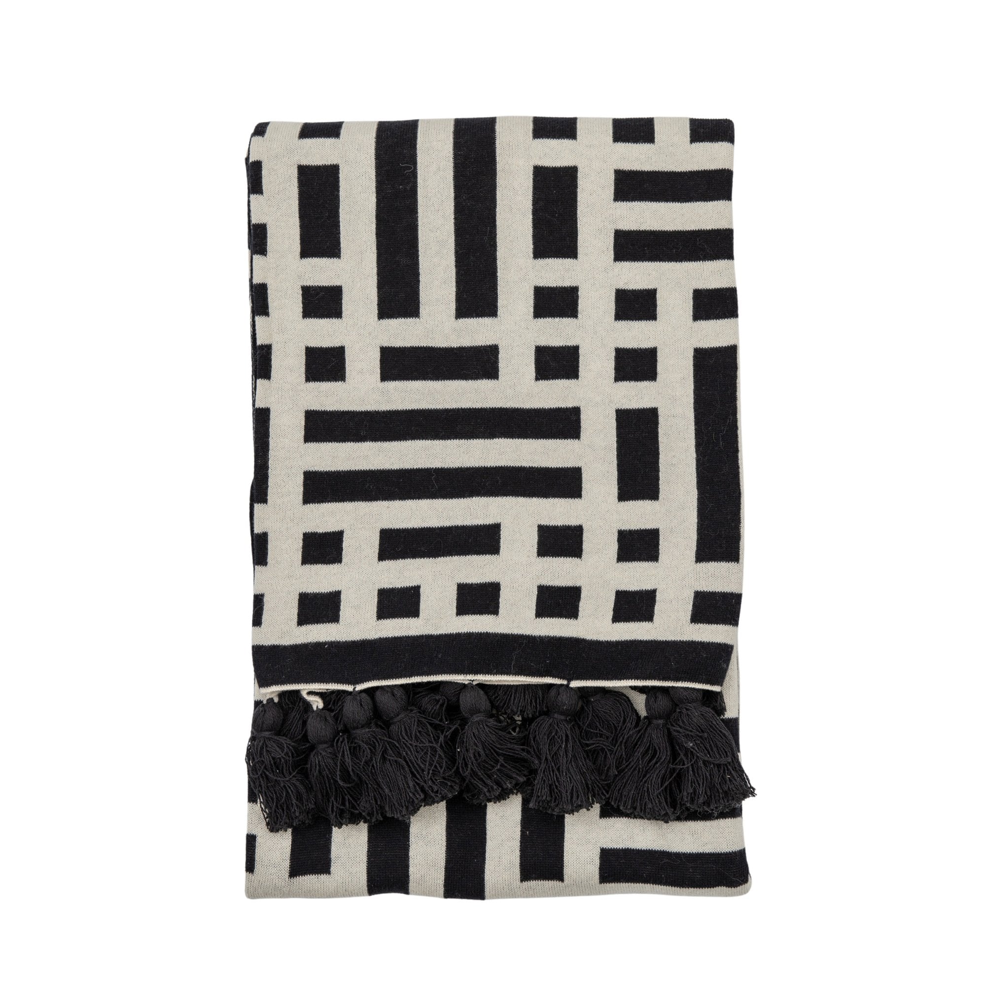 A folded throw with a black and white geometric pattern and black tassels on a white background.