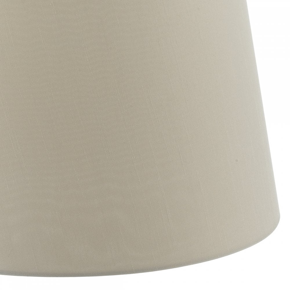 A close-up of the bottom right side of a beige lampshade.