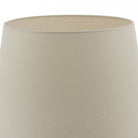 A close-up of the top of a beige lampshade.