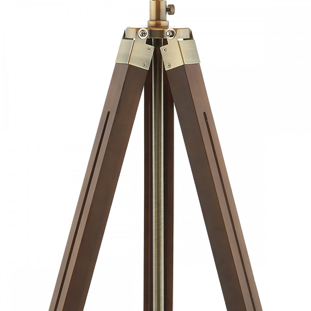 Close-up of the top portion of the tripod lamp's legs made of dark wood and brass.