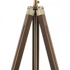 Close-up of the top portion of the tripod lamp's legs made of dark wood and brass.