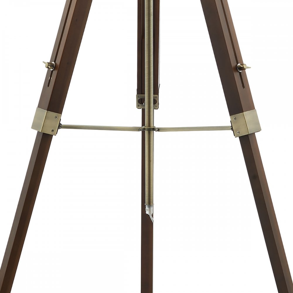 Close-up of the dark wood tripod lamp's legs with brass accents and a central rod.