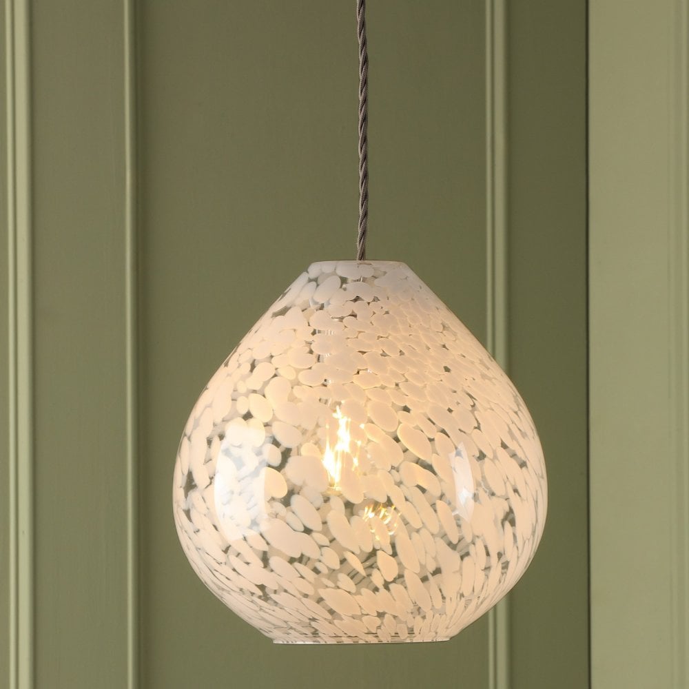 Teardrop pendant light with white and clear speckled glass against a green wall.