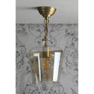 A full view of the pendant light hanging, with the bulb unlit.
