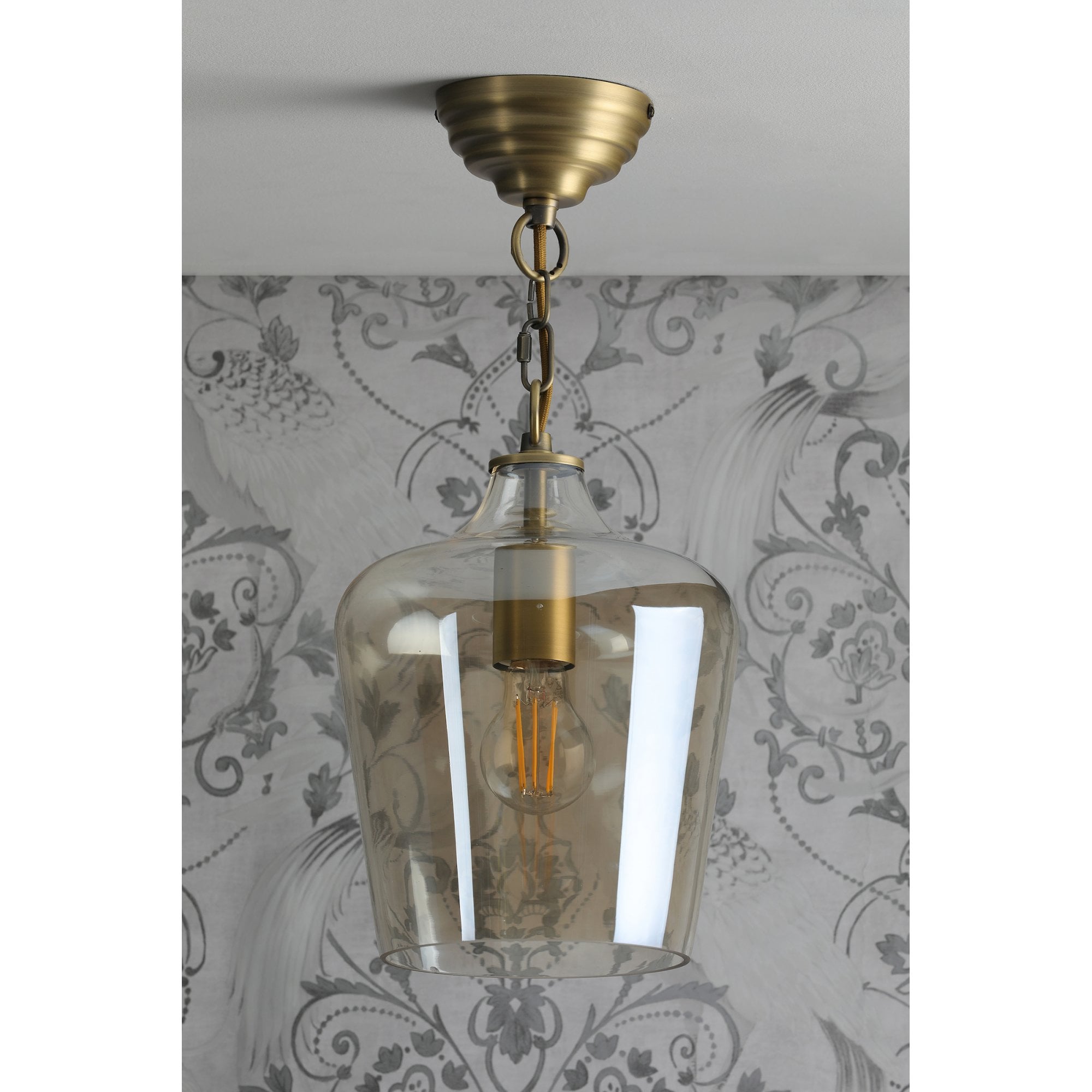 A full view of the pendant light hanging, with the bulb unlit.