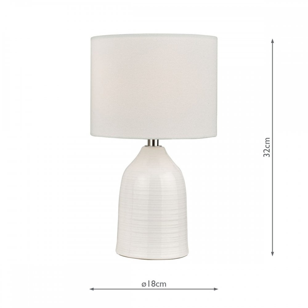 A white ceramic table lamp with a drum shade and dimensions of 32cm height and 18cm diameter.