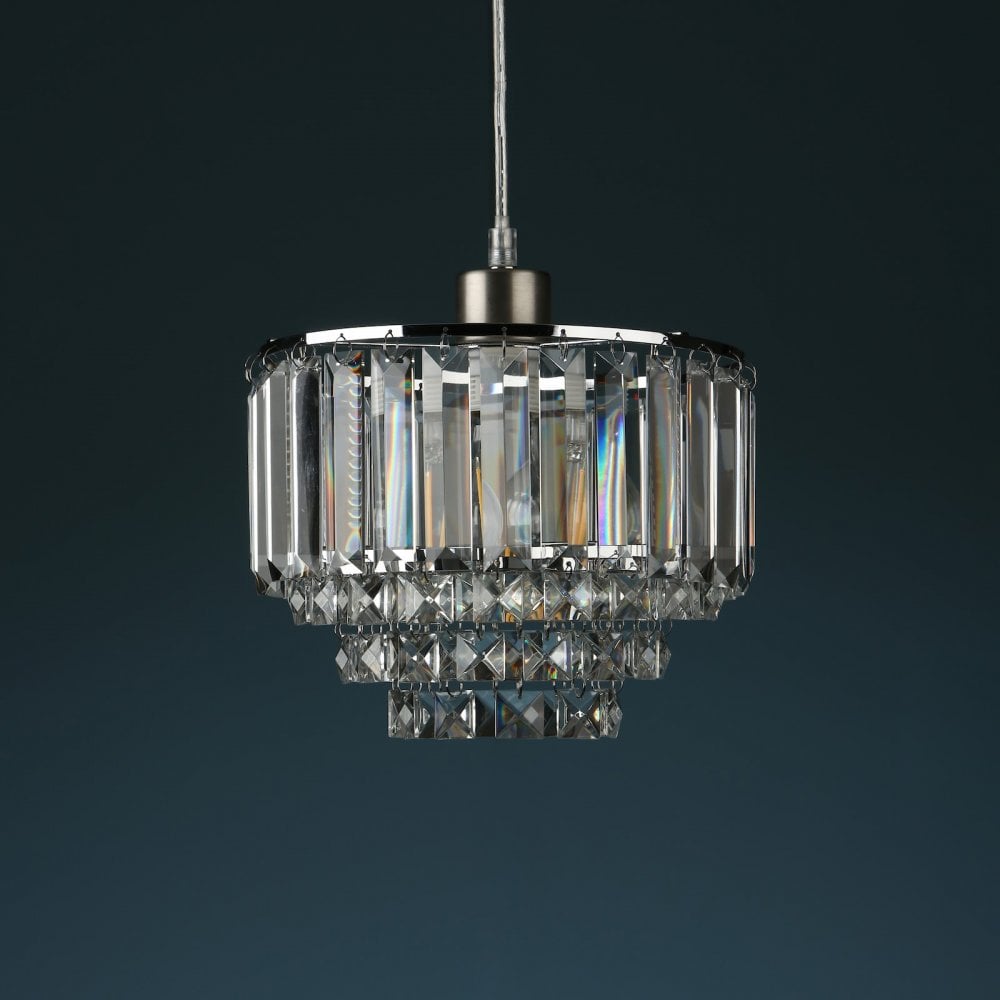 Tiered crystal pendant light, unilluminated, against a dark blue-grey background.