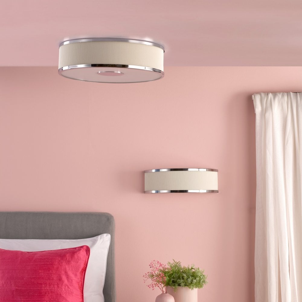 Matching wall and ceiling lights illuminate a bedroom with pink walls and white curtains.