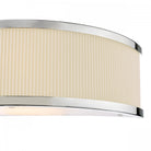 Close-up of a wall light with a ribbed cream shade and polished chrome accents.