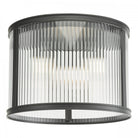 A close up view of a ceiling mounted cylindrical light with fluted glass and a black frame.