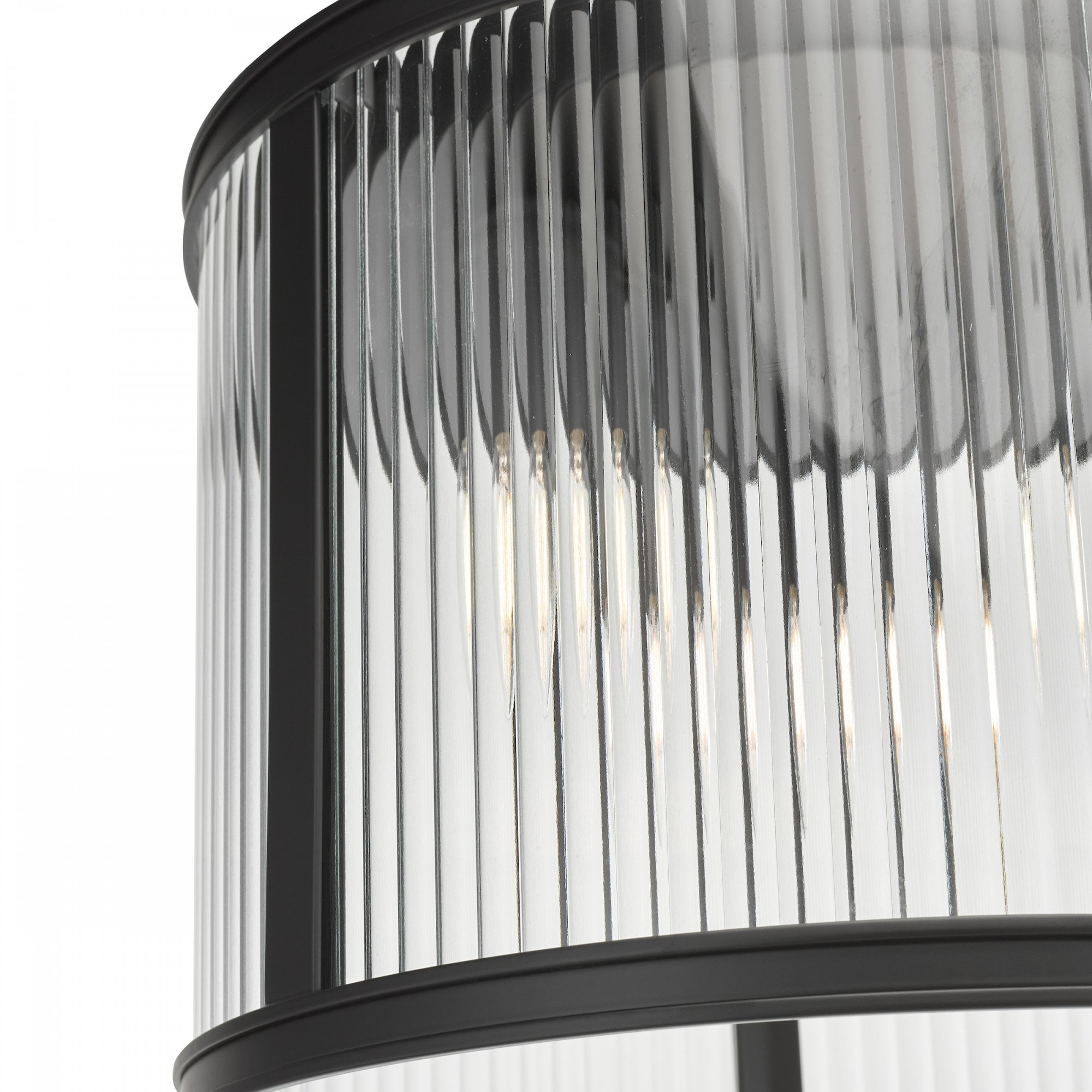 A close up view of a ceiling mounted cylindrical light with fluted glass and a black frame.