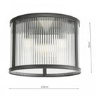 A close up view of a ceiling mounted cylindrical light with fluted glass and a black frame.