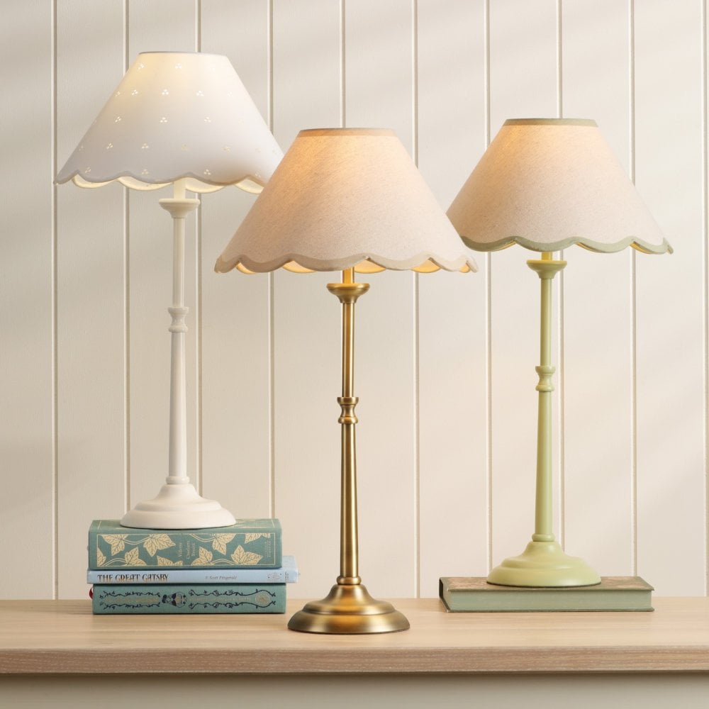 Three table lamps with scalloped shades in different colors and bases.