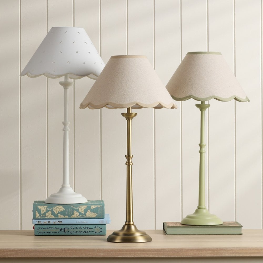 Three elegant table lamps with scalloped shades and varying bases, providing soft lighting.