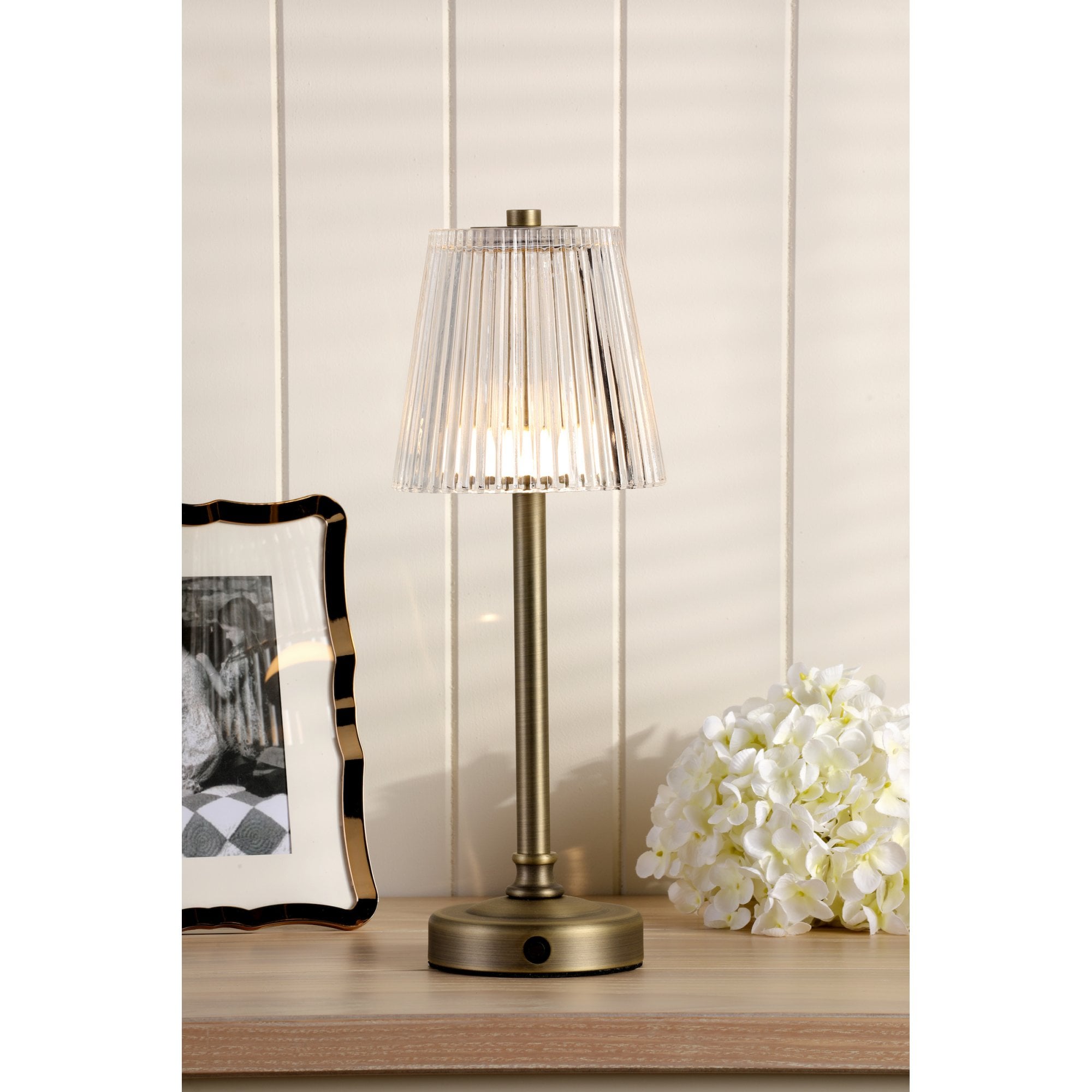 Bronze rechargeable table lamp with a pleated clear plastic shade.