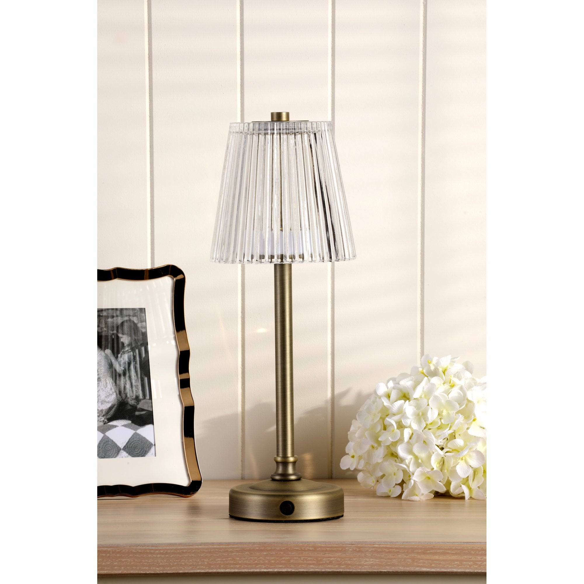 Bronze rechargeable table lamp with a pleated clear plastic shade.