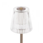 The pleated clear plastic shade of the bronze rechargeable table lamp.