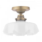 A close-up of a brass ceiling light with a ruffled, translucent glass shade.