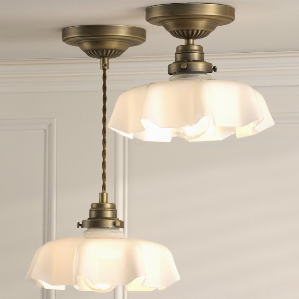 Two brass lights with ruffled translucent glass shades, one a ceiling light, one a pendant.