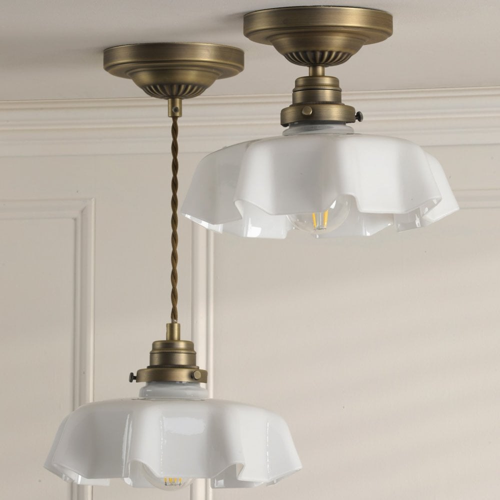 Two brass lights with ruffled translucent glass shades, one a ceiling light and one a pendant.