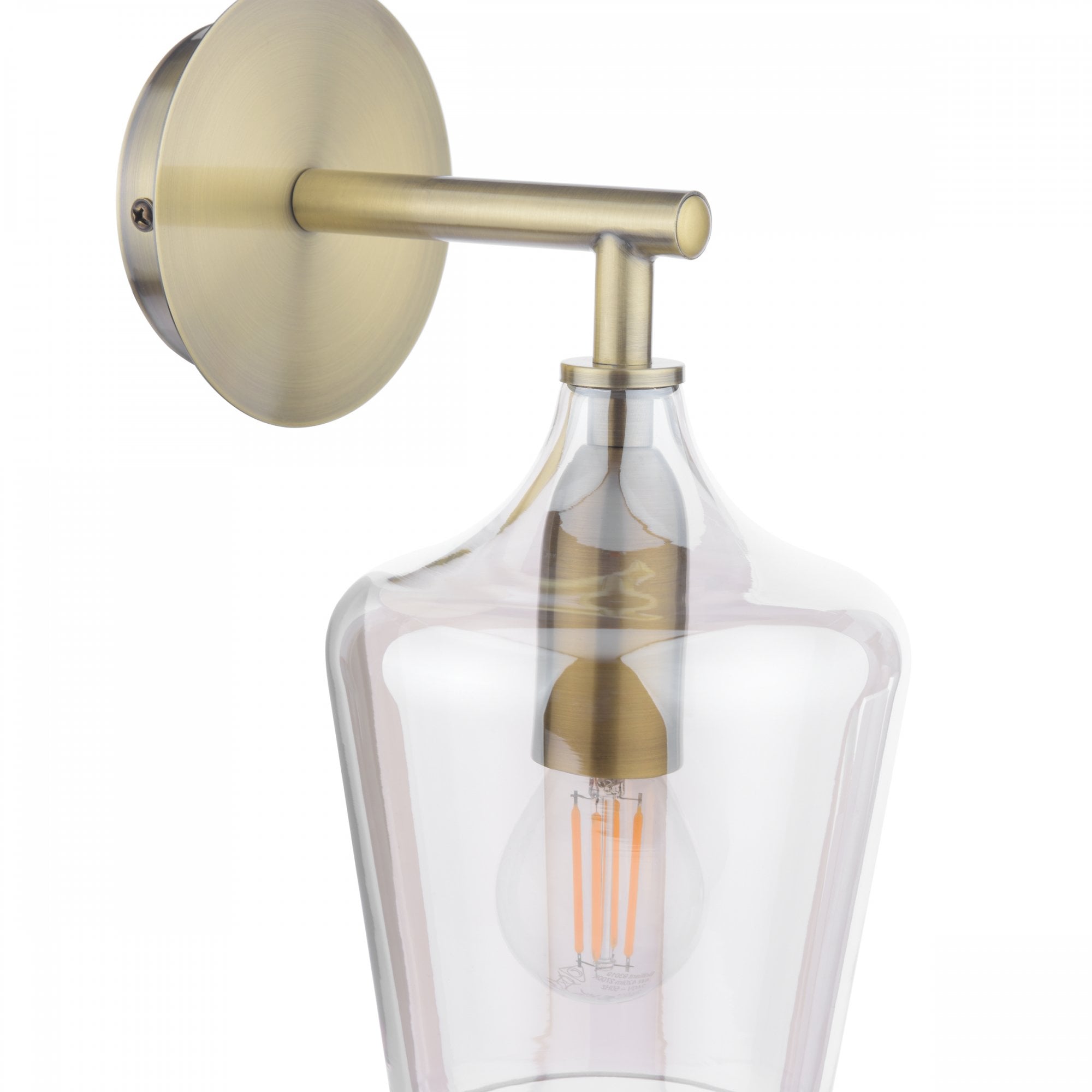 A brass wall light with a clear glass shade, showcasing an LED filament bulb.