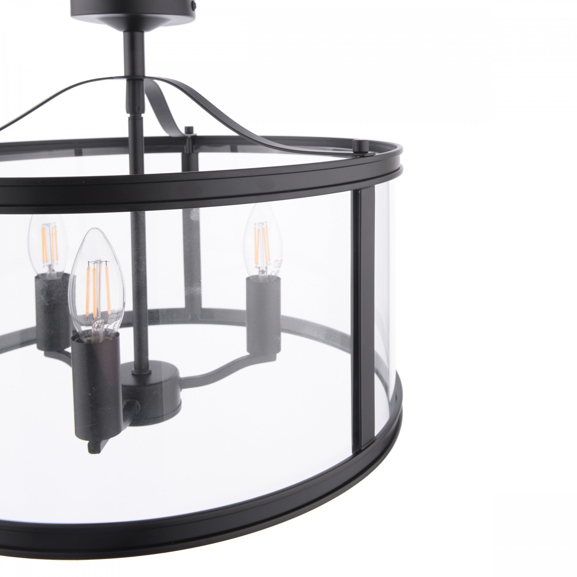Close-up of a black semi-flush ceiling light, showing the clear glass drum and three bulbs.