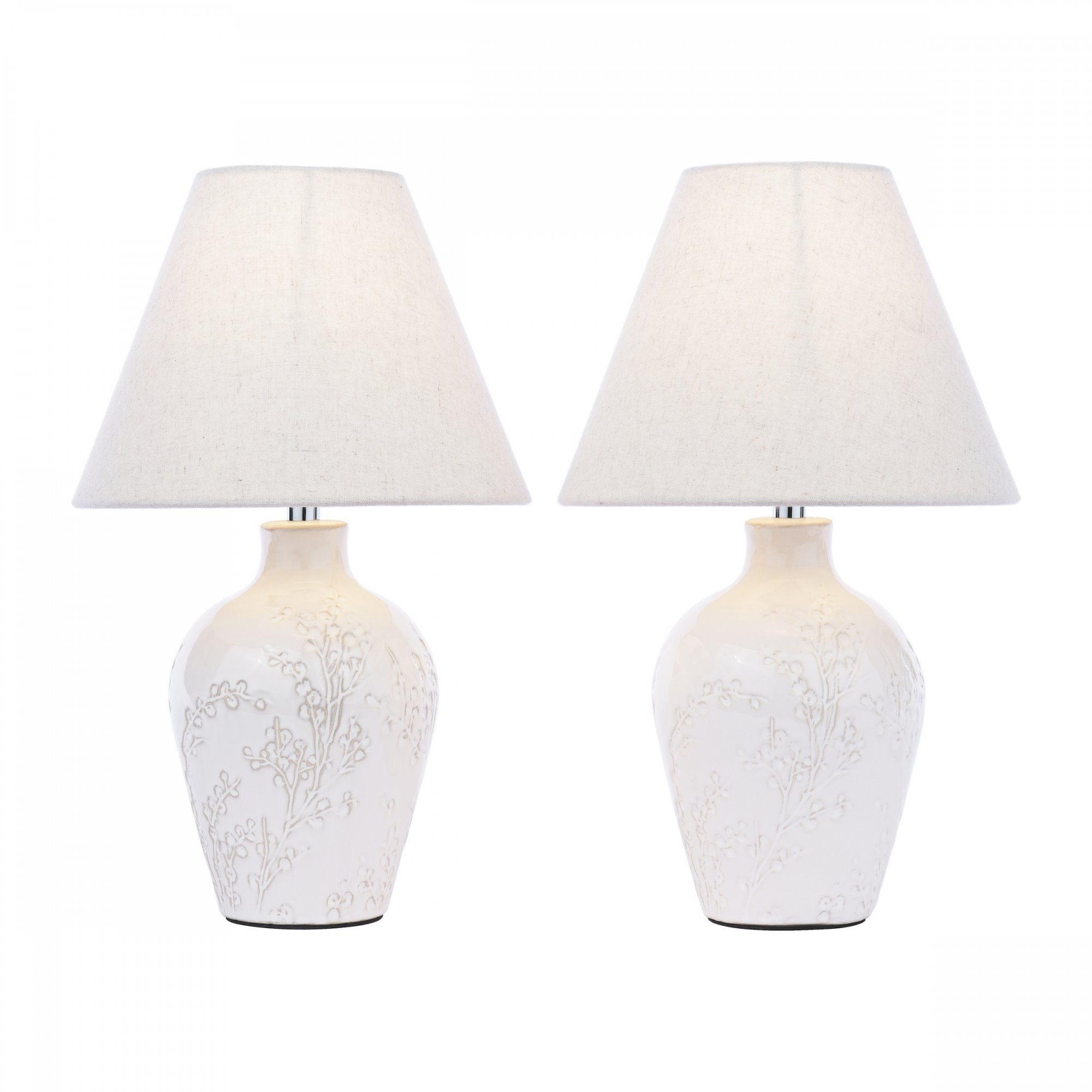 Two white ceramic table lamps with floral patterns and light-colored shades.