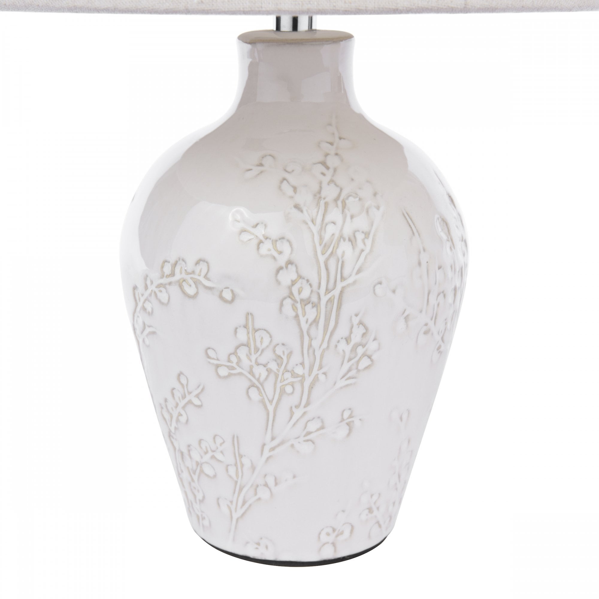 Close-up of a white ceramic table lamp base with intricate floral relief detailing.