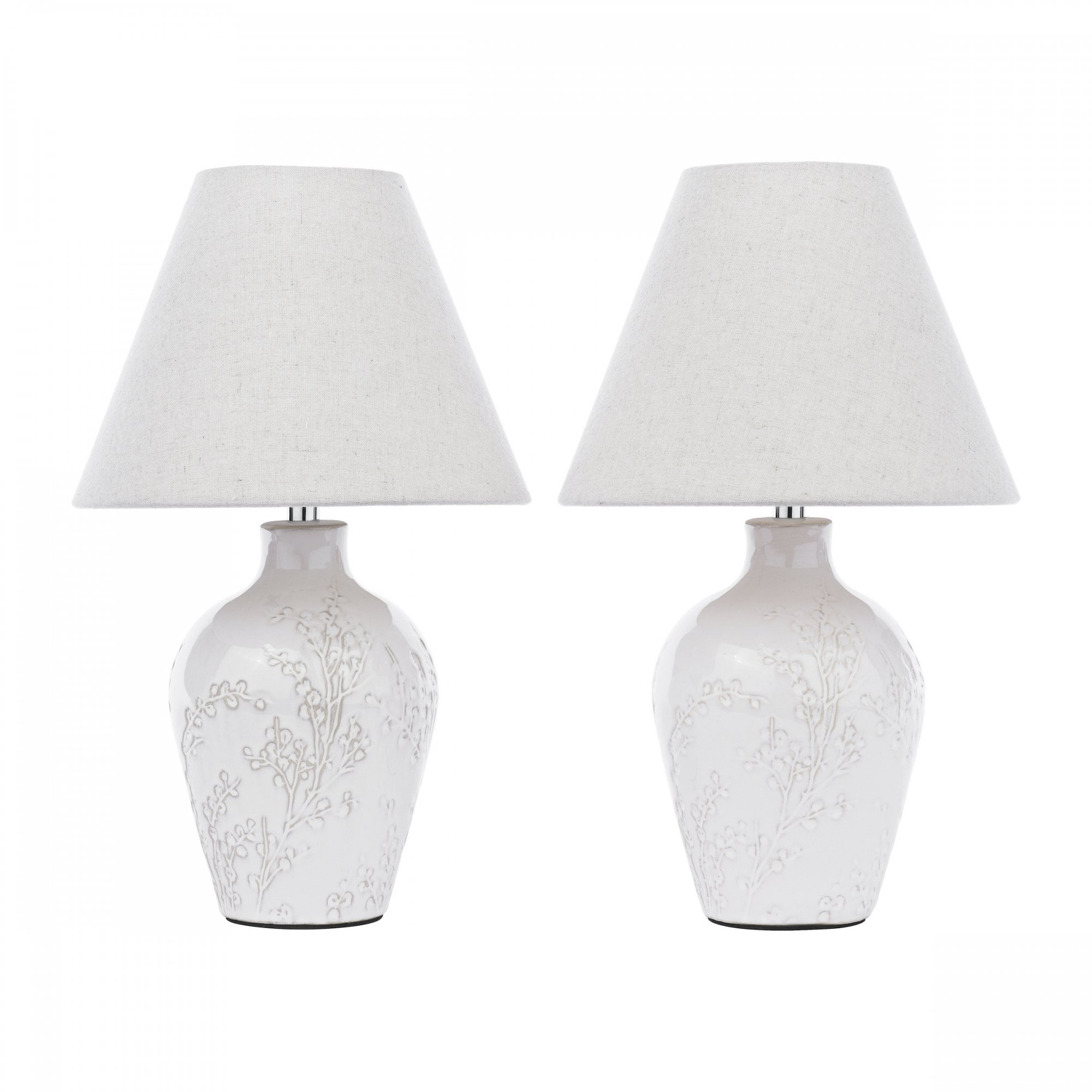Two white ceramic table lamps with floral patterns and light-colored shades.