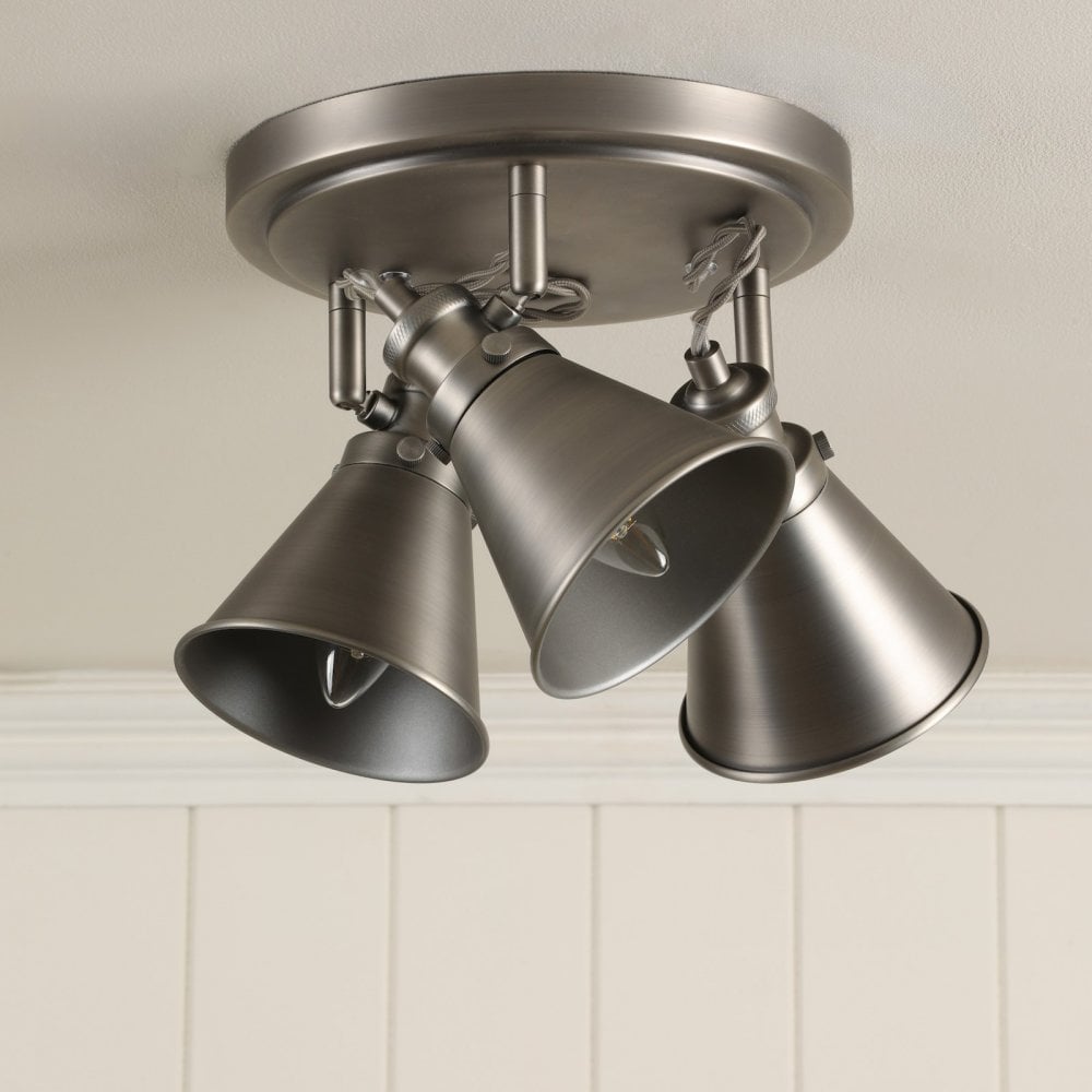 A three-bulb industrial-style ceiling light with no light emanating from each.