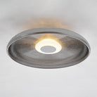 A close-up view of the minimalist ceiling light, showcasing its textured glass and soft glow.