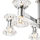 Detailed view of the illuminated crystal shades on a polished chrome chandelier.