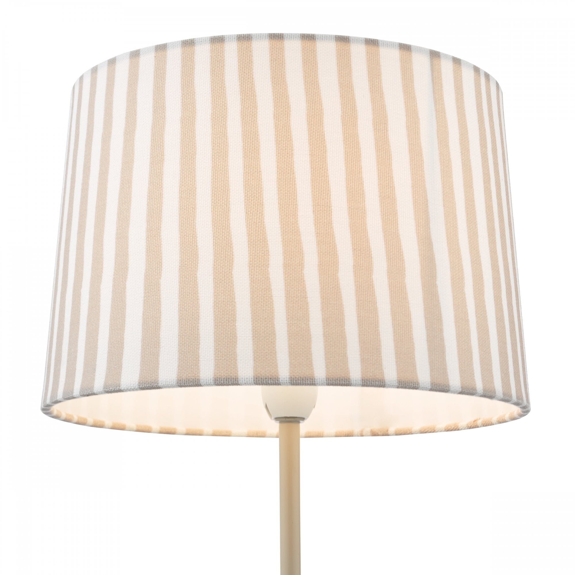 Close-up of a pleated beige and off-white striped lampshade glowing from within.