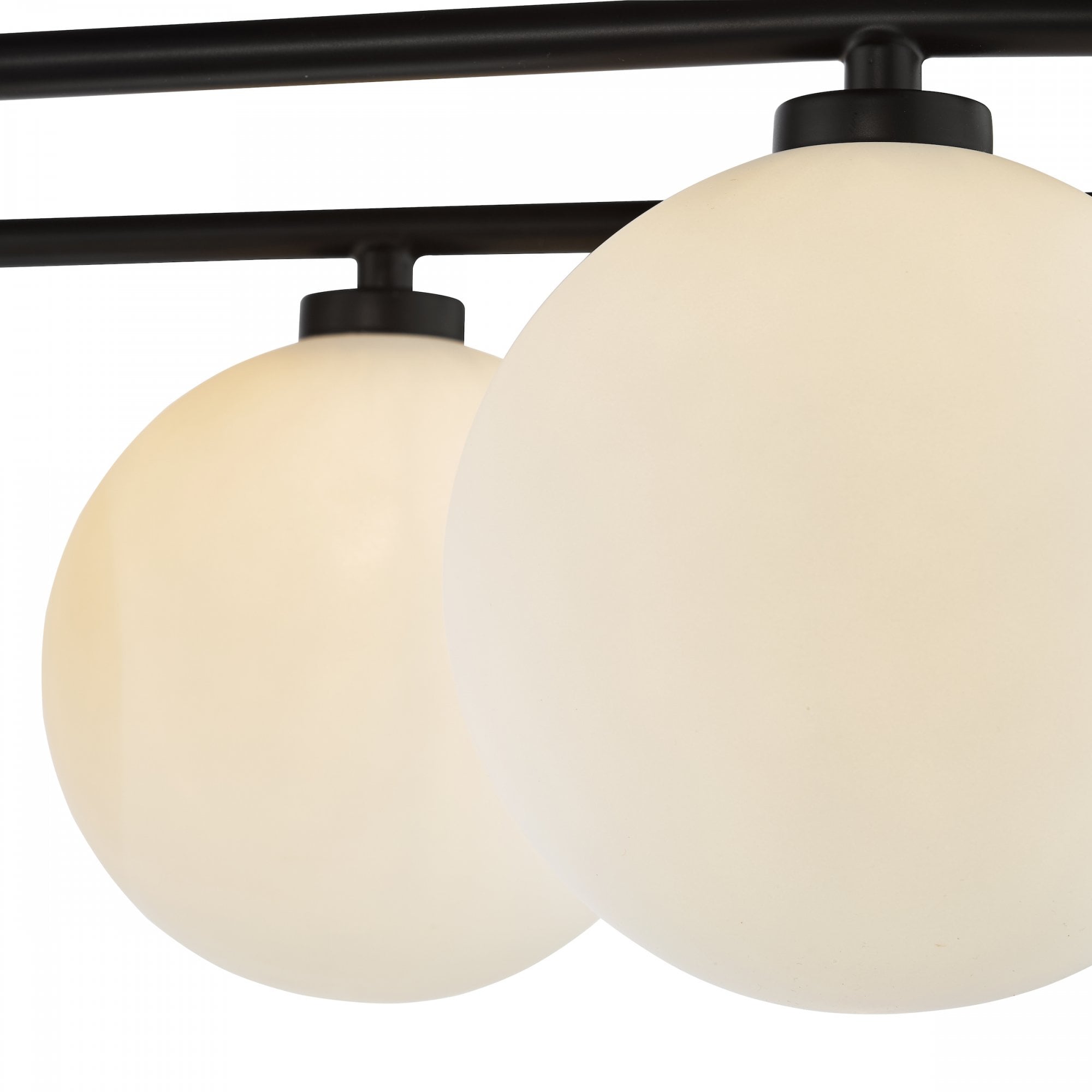 A close-up of two opaque white globe lights with black fittings.