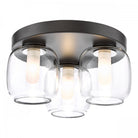 A close-up of a three-light flush mount ceiling fixture with clear glass shades.