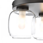 A close-up view of one light on a three-light flush mount ceiling fixture.