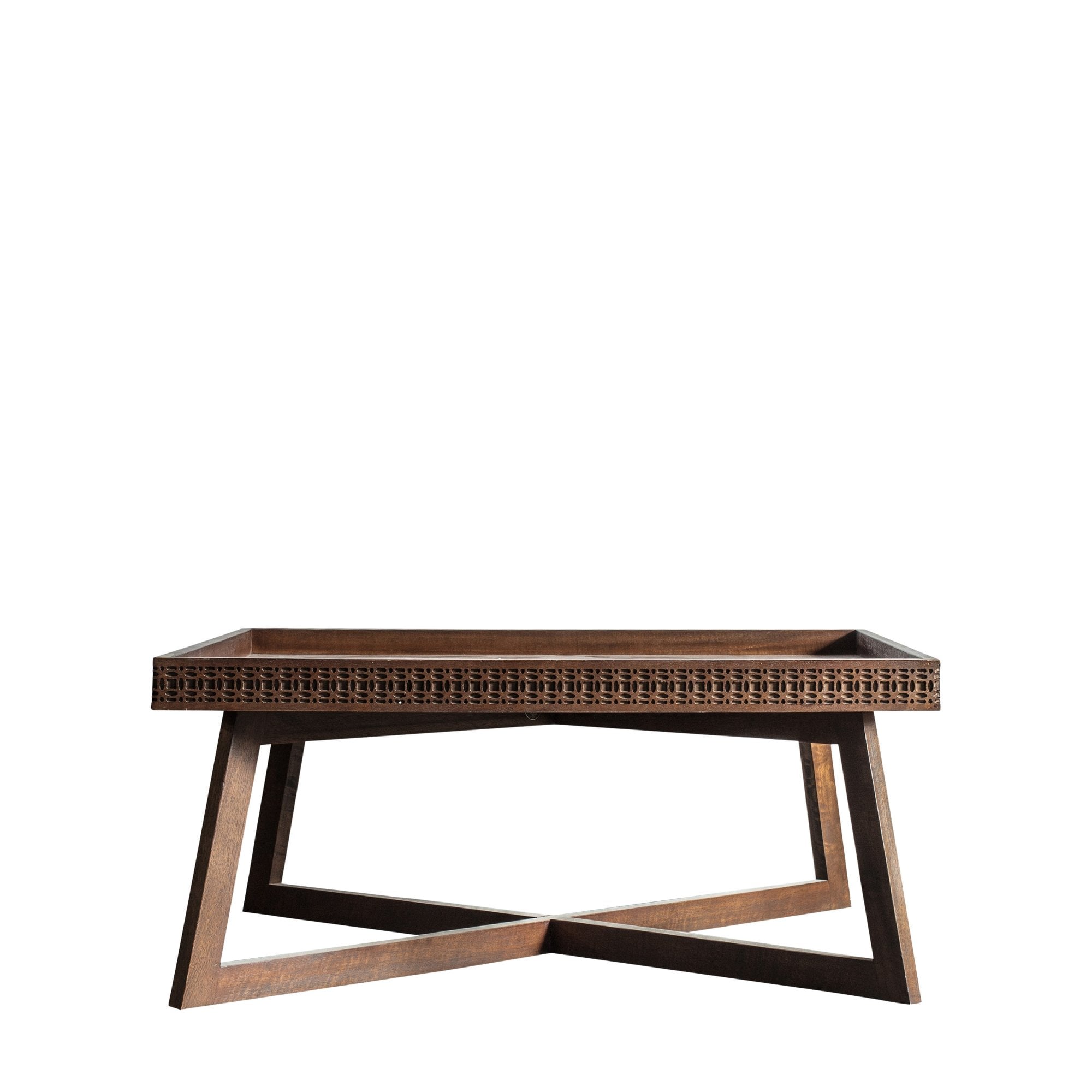 A close-up of a wooden coffee table with a carved pattern.
