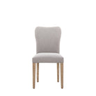 Front view of a single grey fabric upholstered dining chair with light wooden legs.