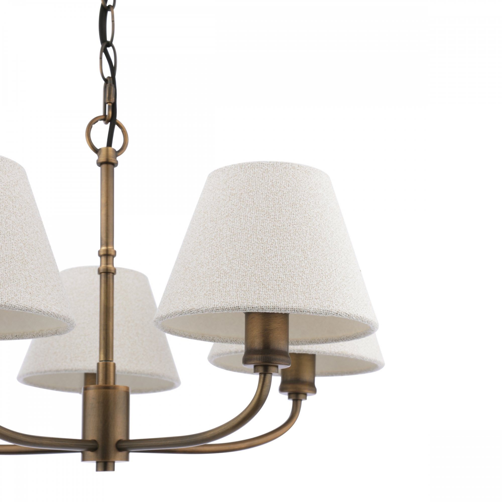 Close-up of a five-light chandelier with textured off-white shades and an antique brass finish.